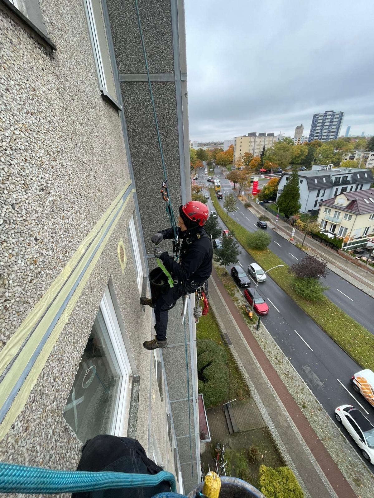 Vorbereitung von Malerarbeiten: Abkleben der Fensterkanten an der Fassade im Seilzugang